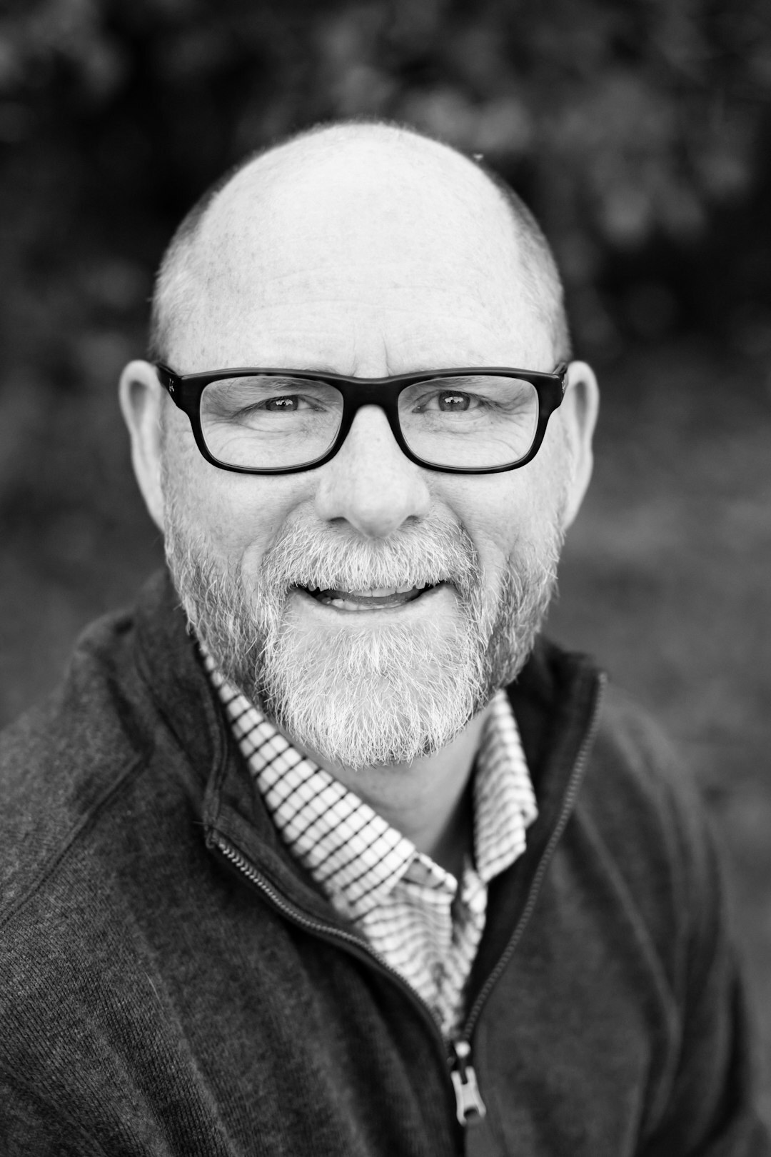 Studio portrait of a man with glasses and a warm smile