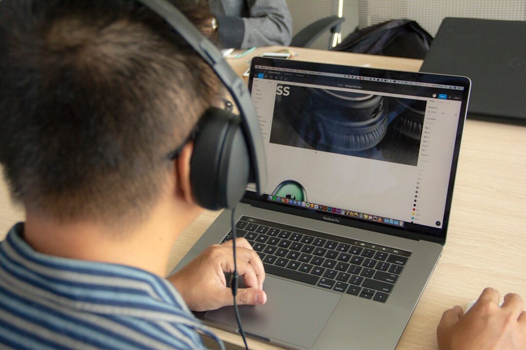 Person reviewing video footage on a laptop with headphones